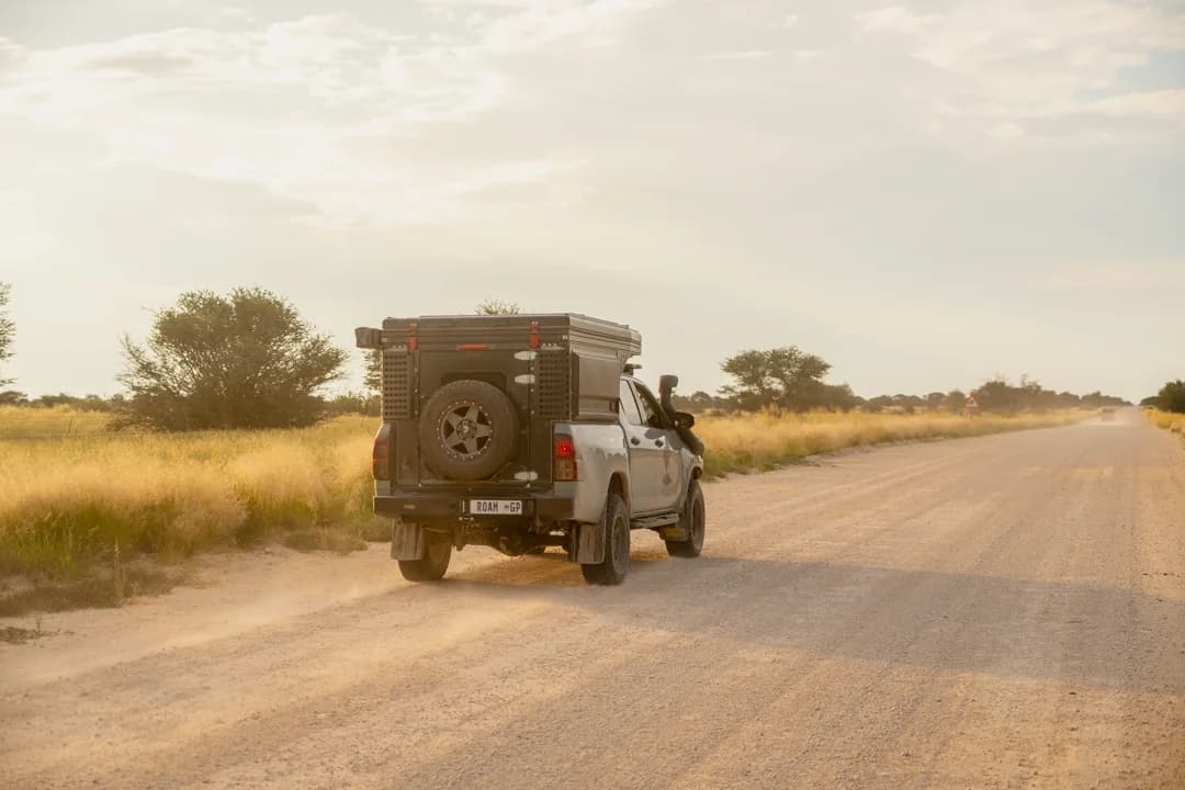 A Hilux with a Bushtech canopy on a sand road