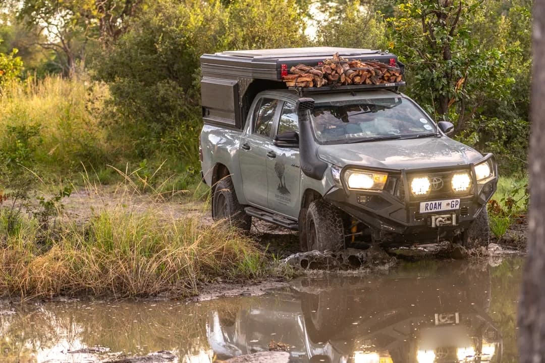 A Hilux with a Bushtech canopy in a water crossing